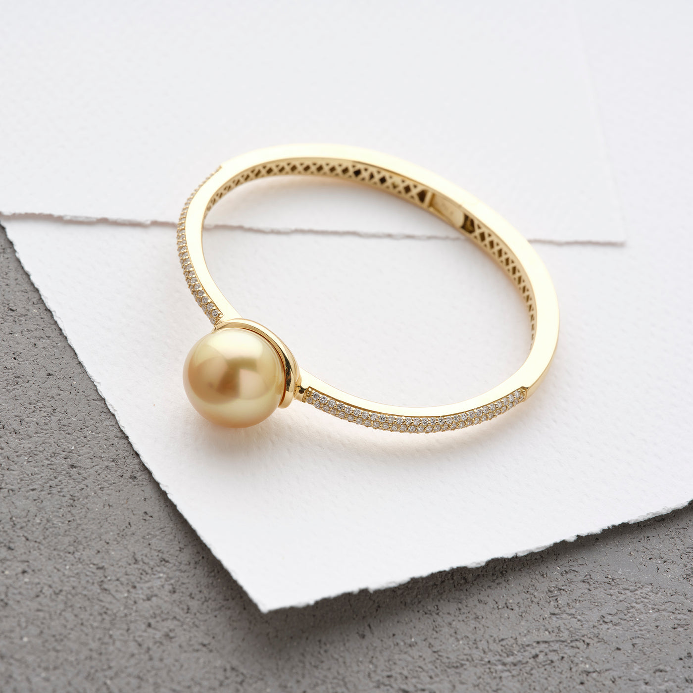 Available in elegant Golden or White South Sea Pearl Bracelet. Crafted in yellow gold, this hinge-style bracelet is accentuated with sparkling diamonds.