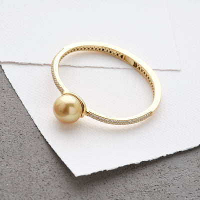 Available in elegant Golden or White South Sea Pearl Bracelet. Crafted in yellow gold, this hinge-style bracelet is accentuated with sparkling diamonds.