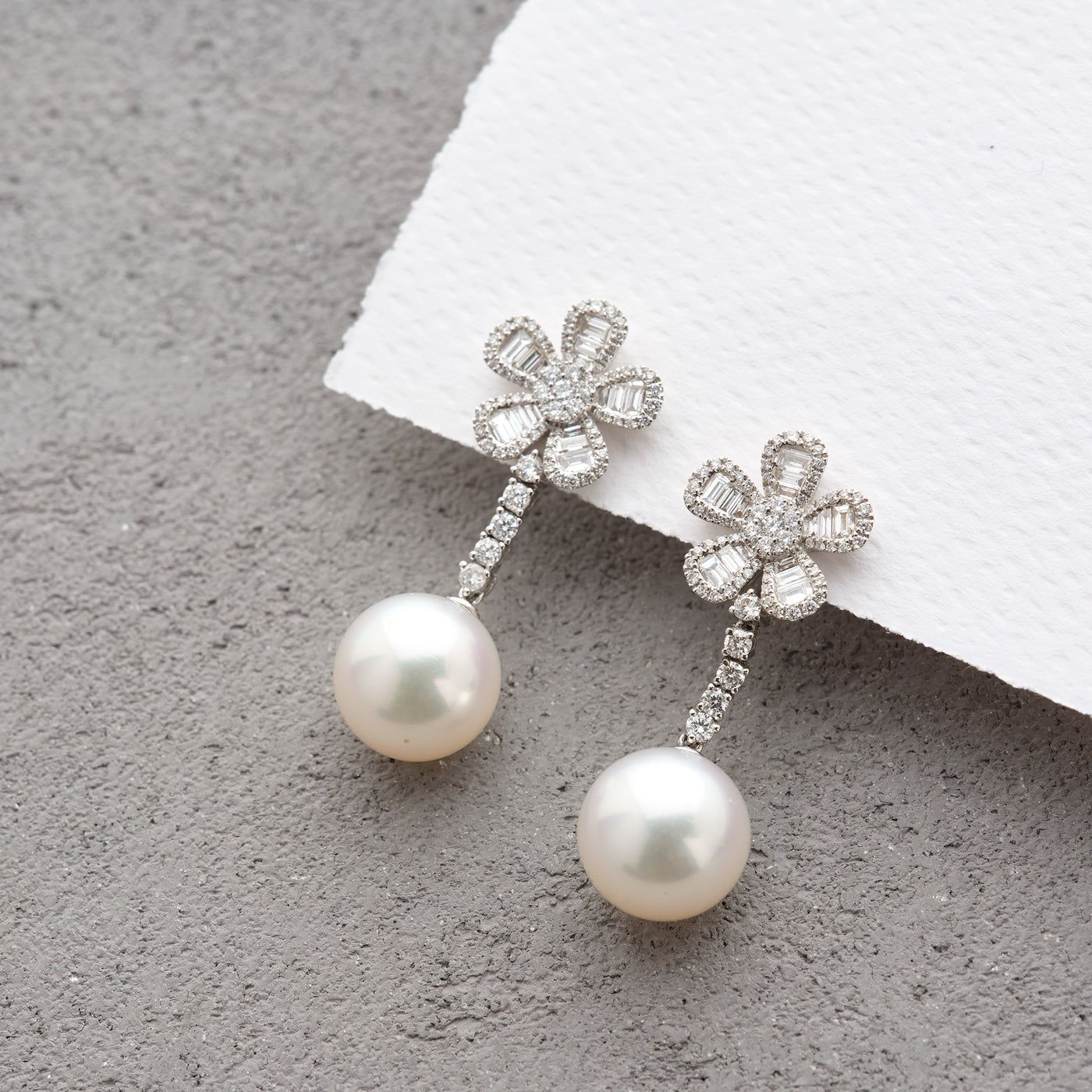 Exquisite White South Sea pearls that drop from a playfully elegant 5 petal diamond flower for each earring.