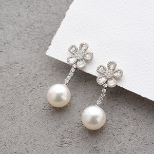 Exquisite White South Sea pearls that drop from a playfully elegant 5 petal diamond flower for each earring.